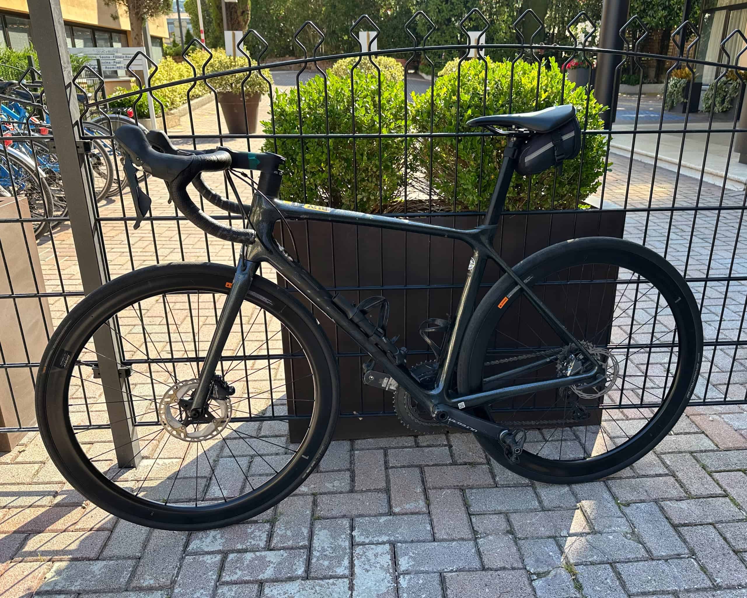 Musta Giant TCR Advanced Pro -maantiepyörä nojaamassa aitaan.